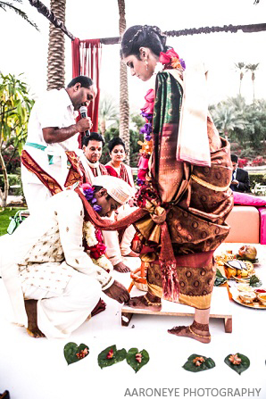 The groom places a ring on the foot of the bride.