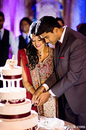 An Indian bride and groom wed in a traditional Hindu wedding ceremony under a green and purple mandap. The then bride chooses a red and white lengha for her reception.