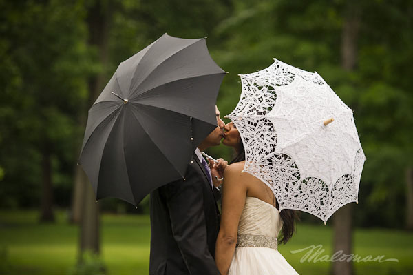 indianbrideandgroomoutsideweddingkissingumbrellas