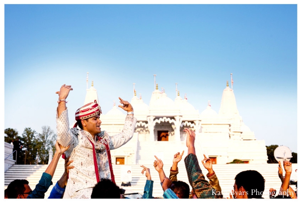 An indian groom arrives to his indian wedding in a baraat.