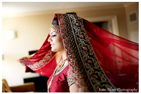 Indian bride dresses in a traditional red lengha for her Indian wedding.