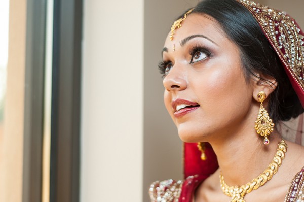 This Indian bridal makeup includes long lashes, a red lip and subtle blush.