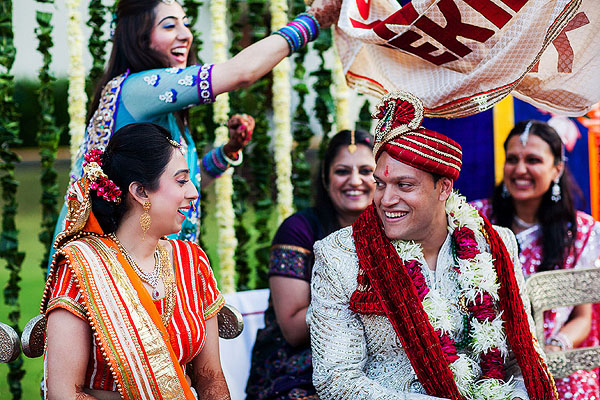 The groom sees his Indian bride for the first time in her bridal outfit.