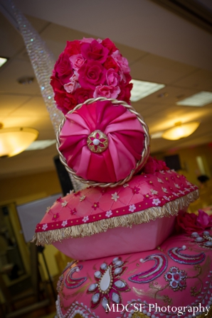 Stack of pillows for Indian wedding cake at a pink themed reception.