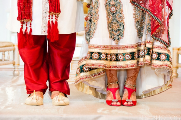 An Indian bride and groom show off their Indian wedding outfits.