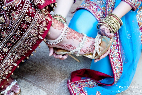 Indian bride puts on indian bridal heels.