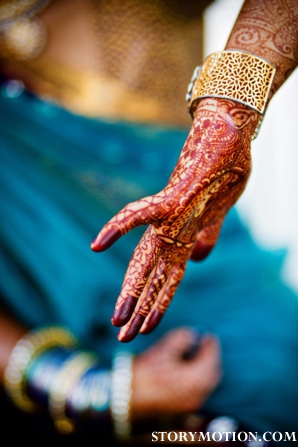 Indian bride with traditional bridal mehndi on her hands.