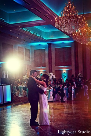 Indian bride and groom dance at indian wedding reception.