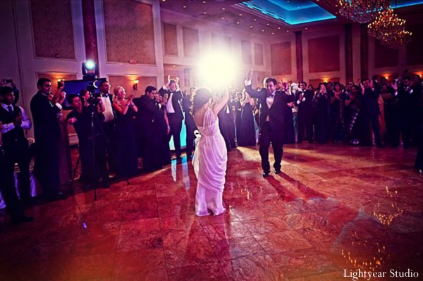 Indian bride and groom dance at modern indian wedding reception.