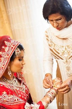 This beautiful bride prepares for her fabulous wedding with a professional pamper session. Her hair, makeup, and red lengha are gorgeous!