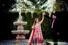 An Indian bride and groom celebrate at their pink themed reception.