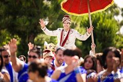 This Indian wedding ceremony features bright red roses and a bridal party dressed in bold blue saris. The bride and groom are glorious in traditional wedding clothes.