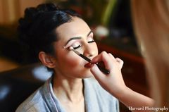 An Indian bride gets her hair and makeup perfected for her wedding.