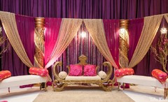 An Indian bride and groom celebrate at their wedding reception. They choose a bold pink palette.