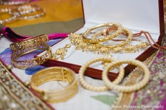 This Indian bride is getting all dolled up for her traditional ceremony. She's dressed in a beautiful pink and gold sari!