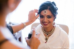 This Indian bride prepares for her traditional wedding with gorgeous hair and makeup.