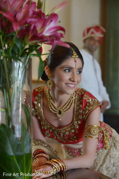 This Indian bride is beautiful in a red lengha with gold jewelry.