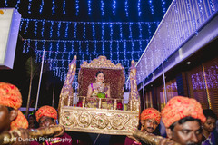 This Indian bride is carried in on a beautiful palanquin at her wedding ceremony.