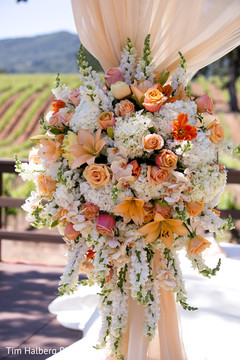 This outdoor Indian wedding ceremony features beautiful floral and decor.