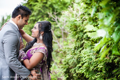 An Indian bride and groom pose for portraits before their opulent wedding reception.