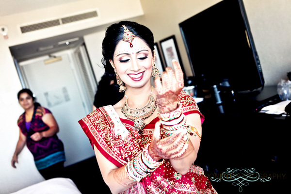 An Indian bride slips on churis, traditional Indian bracelet jewelry.