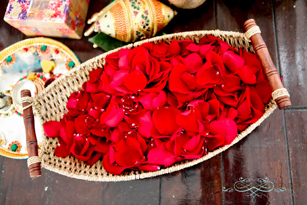 Indian wedding decor features bright colors, like these lovely red rose petals.