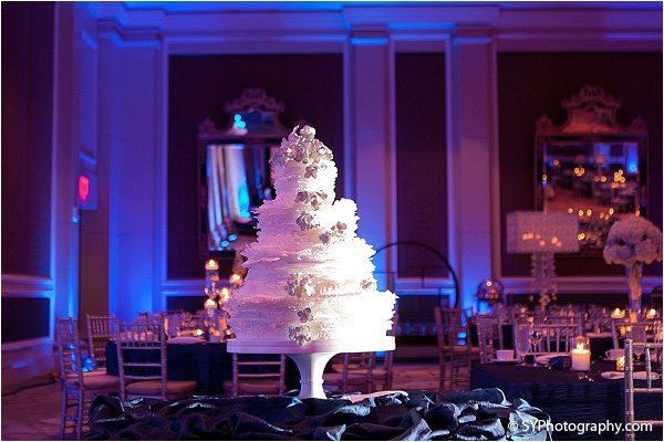 A four tiered Indian wedding cake stands tall at this elegant Indian wedding reception.