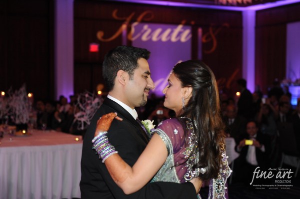 An Indian bride and groom dance at their modern purple indian wedding reception.