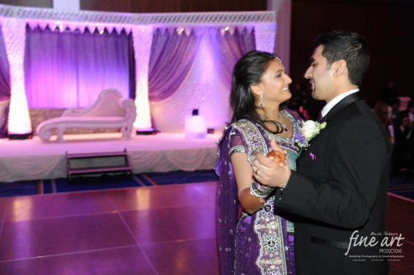 An Indian bride and groom dance at their Indian wedding reception.