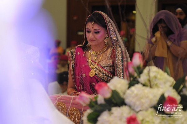 Indian bride wears a traditional bridal lengha in pink.