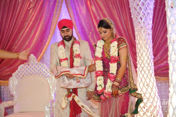 An Indian bride and groom wearing modern indian wedding wear.