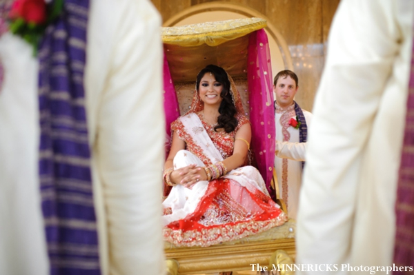 An Indian bride enters her indian wedding on a palanquin.