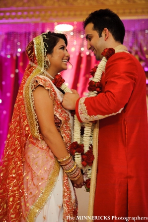 an indian bride and groom in traditional hindu wedding outfits.