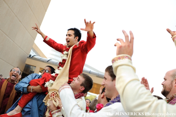 A groom is hoisted on top of shoulders as he arrives to his indian wedding ceremony.