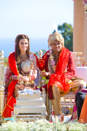 An Indian bride and groom in traditional indian wedding outfits.