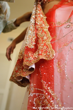 An indian bride is wrapped in a bridal lengha.