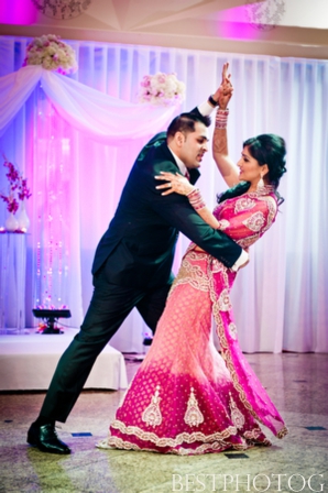 An Indian bride and groom have their first dance at their Indian wedding reception.