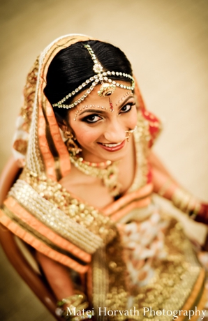 Indian wedding photography captures an Indian bride in gold bridal jewelry.