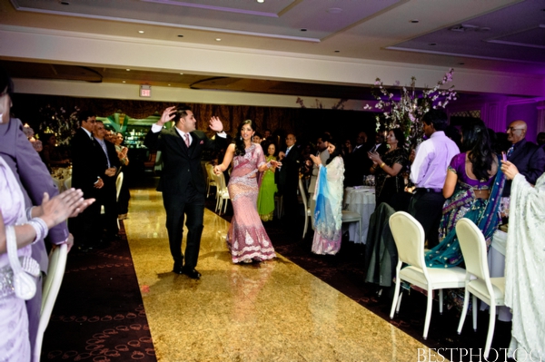 An Indian bride and groom enter a modern Indian wedding reception.