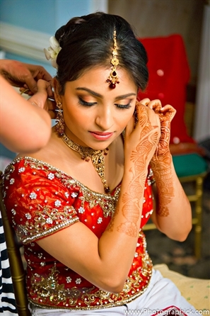 Indian bride wears red bridal lengha at indian wedding.