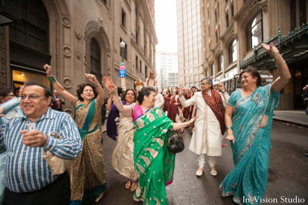 Indian wedding party goers dance at baraat.