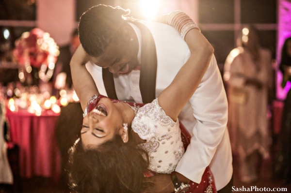 Indian wedding reception with indian bride and groom dancing.