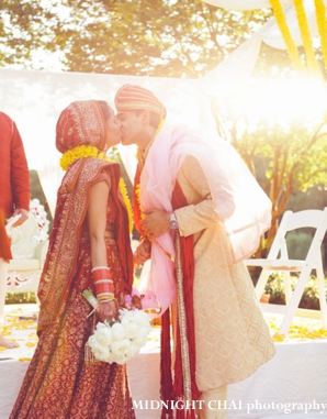 indian bride and groom kiss at indian wedding ceremony