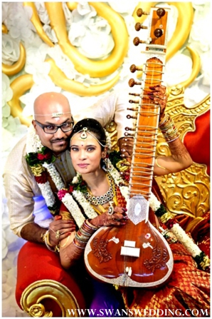 South Indian bride and groom take portraits with sitar.